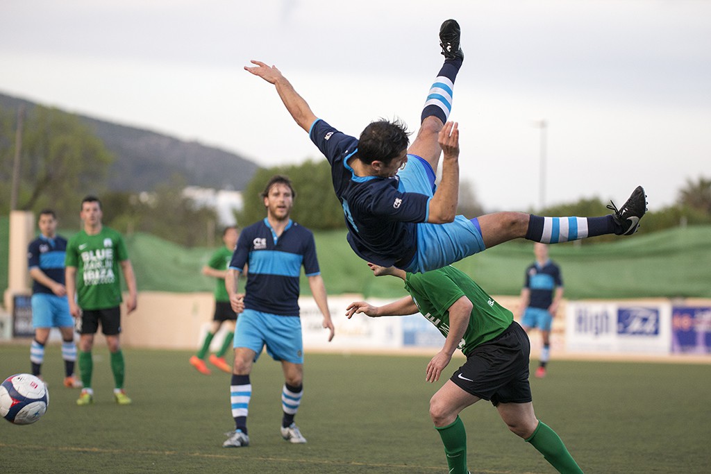 Un jugador del Ciudad de Ibiza cae a la hierba de espaldas en un lance del partido (Fotos: Francisco Natera).